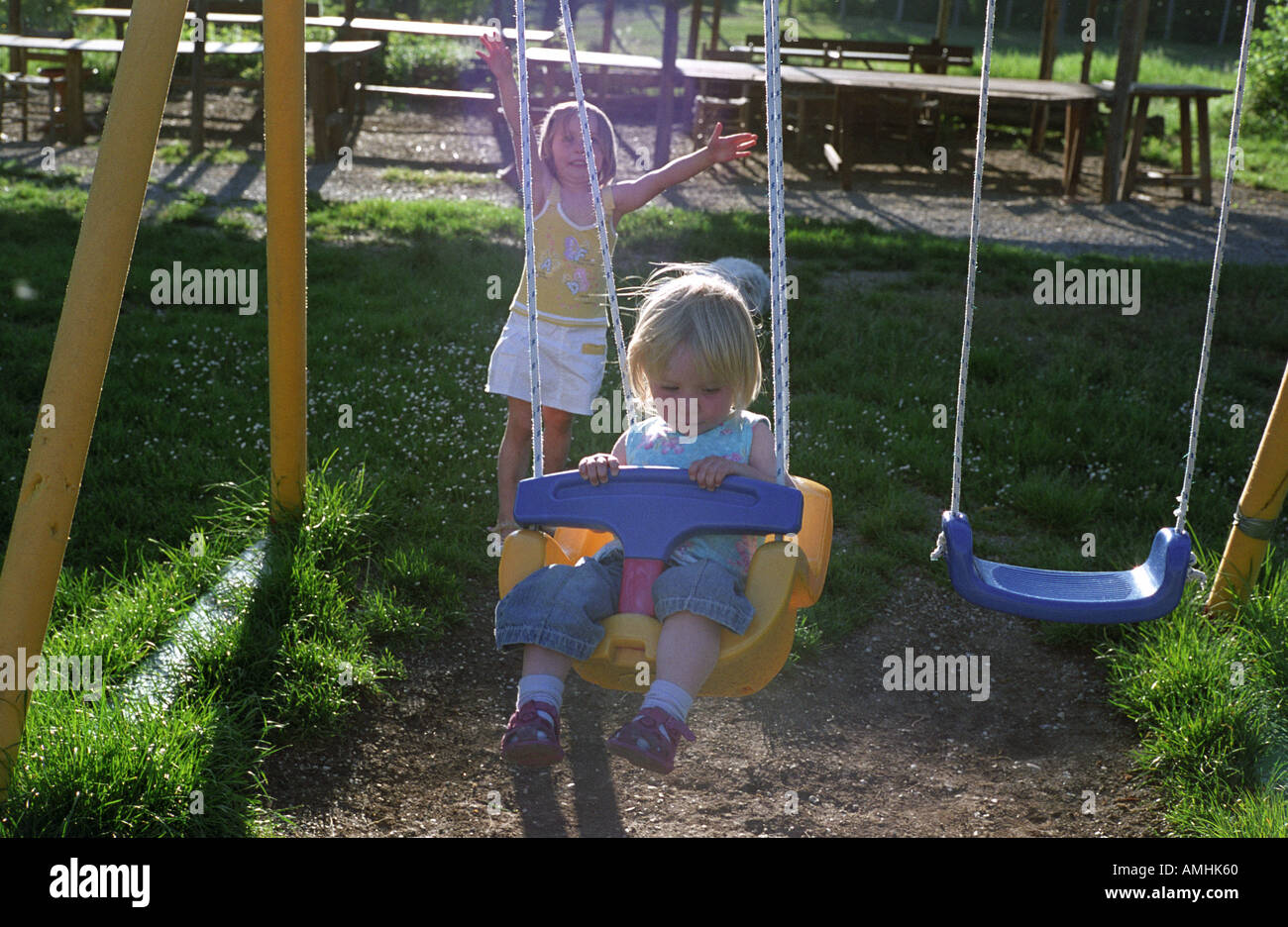 two little girls play on swing  Stock Photo