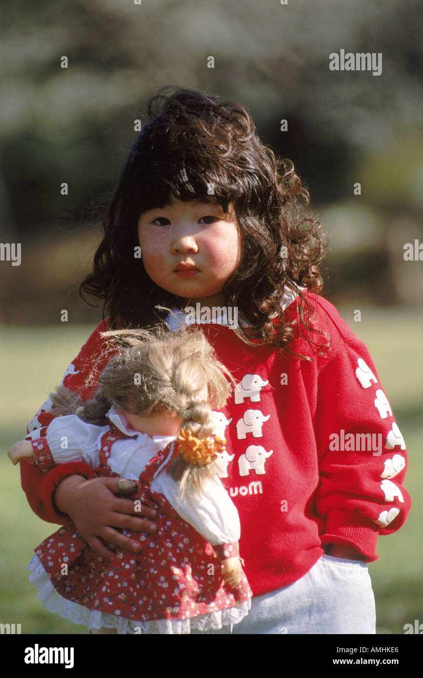 Japanese girl with rosy cheeks and favorite doll Stock Photo