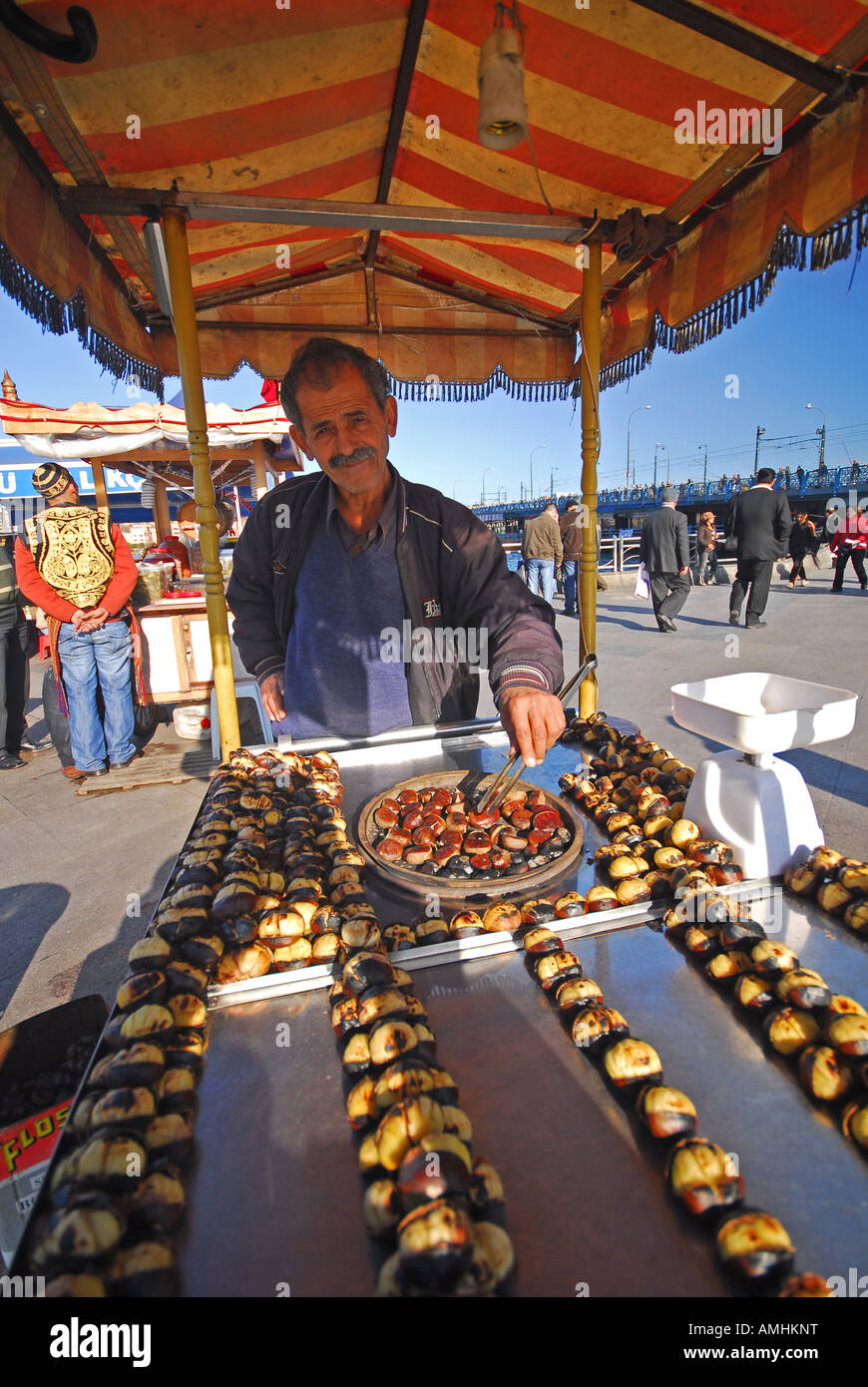 ISTANBUL. Man selling hot roast chestnuts by the Golden Horn waterfront in Eminonu. 2007. Stock Photo