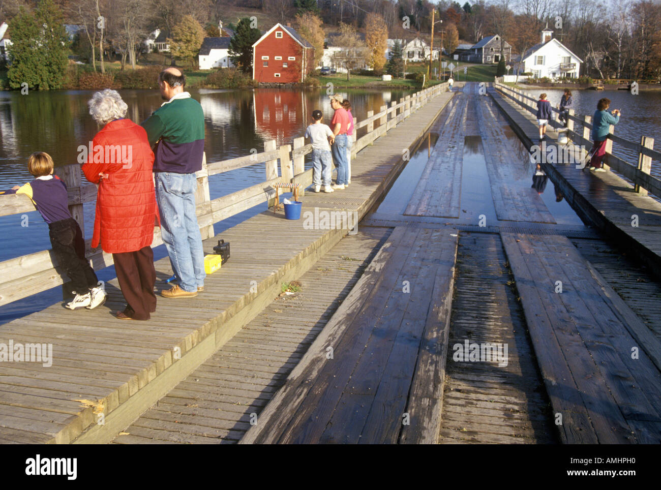 People walking on Brookfield Floating Bridge over Sunset Lake