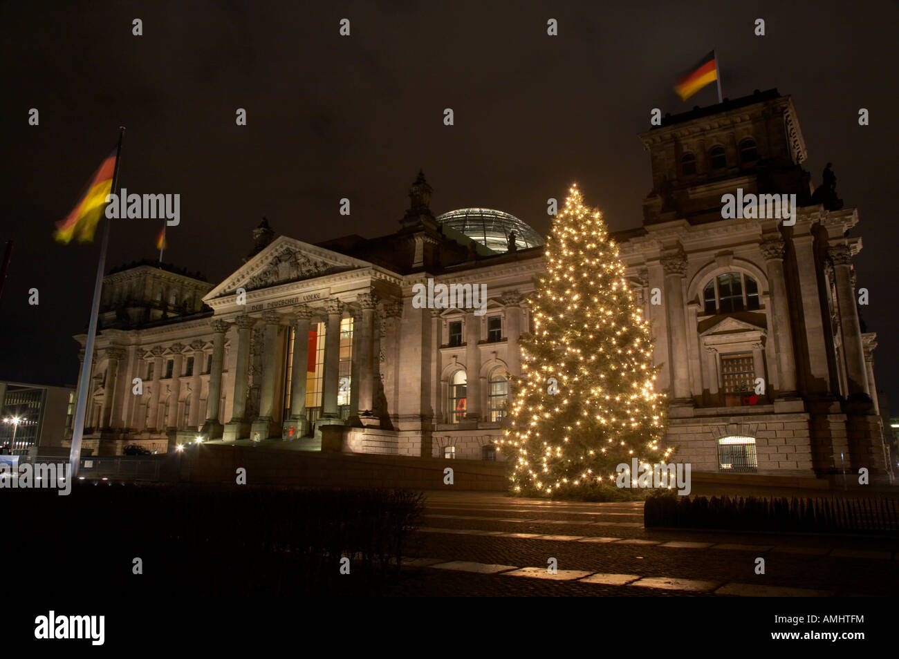 christmas tree and german flag flying fluttering on flagpole outside reichstag building Berlin Germany Stock Photo