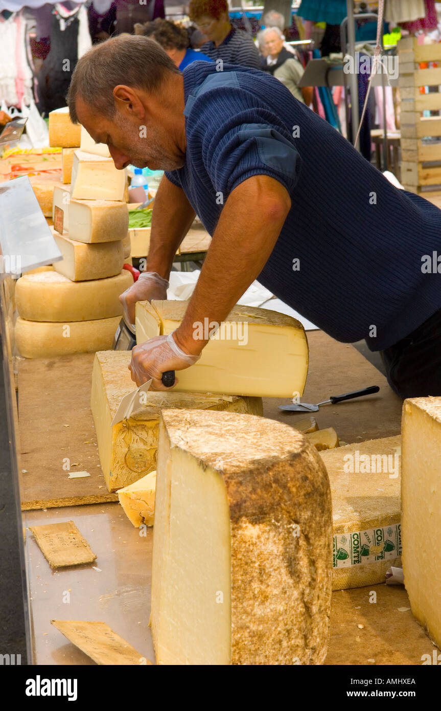 Man cutting cheese at a cheese stall in Trouville market in Normandy France Stock Photo