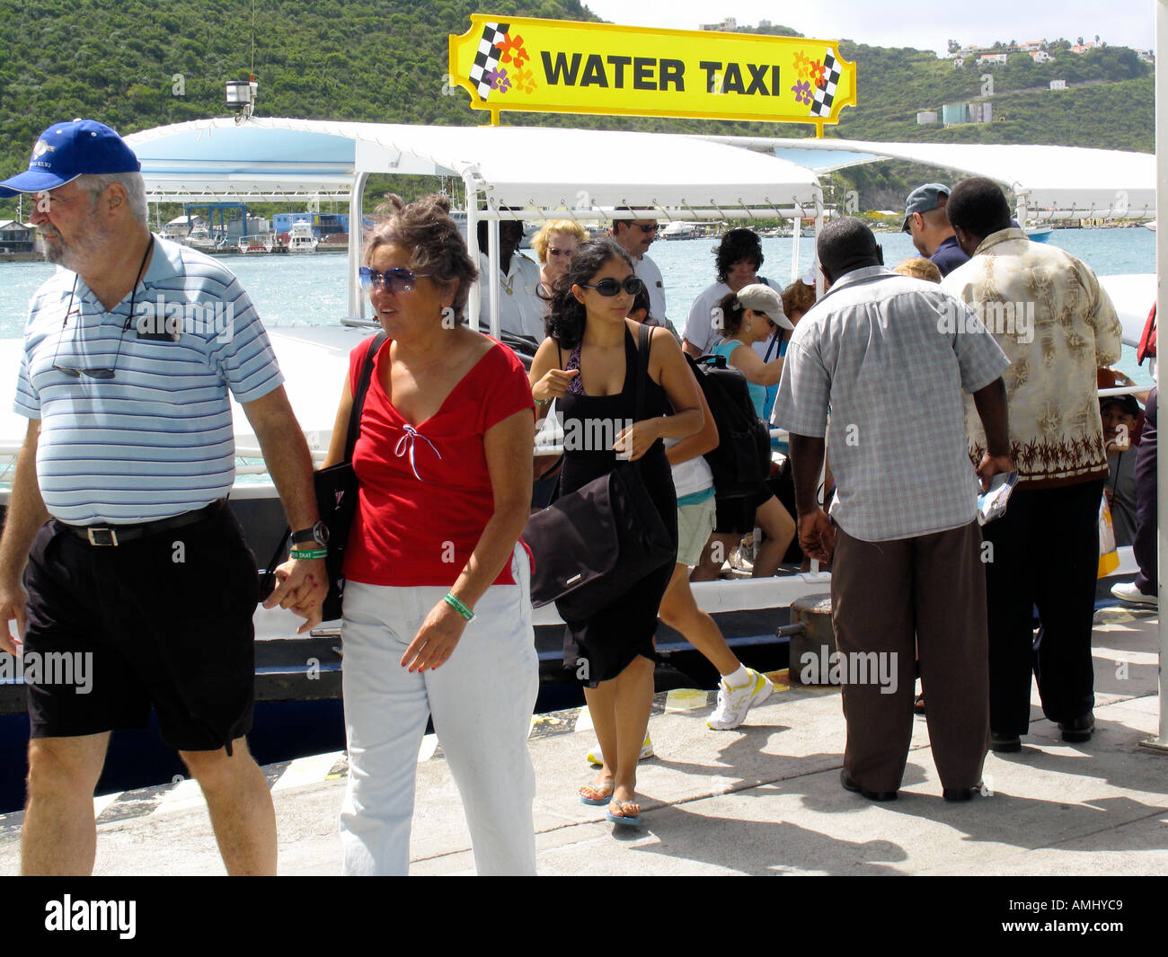 Cruise ship visitors arrive by water taxi on jetty in duty free