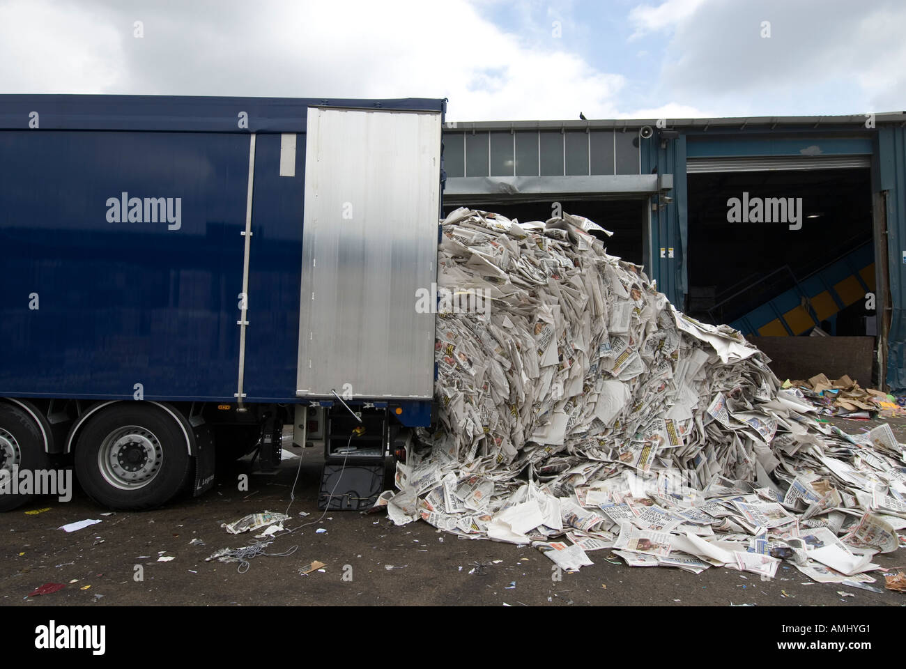 Lorry unloading pile of returned newspapers to paper recycling facility