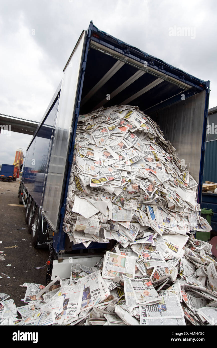 Lorry unloading pile of returned newspapers to paper recycling facility