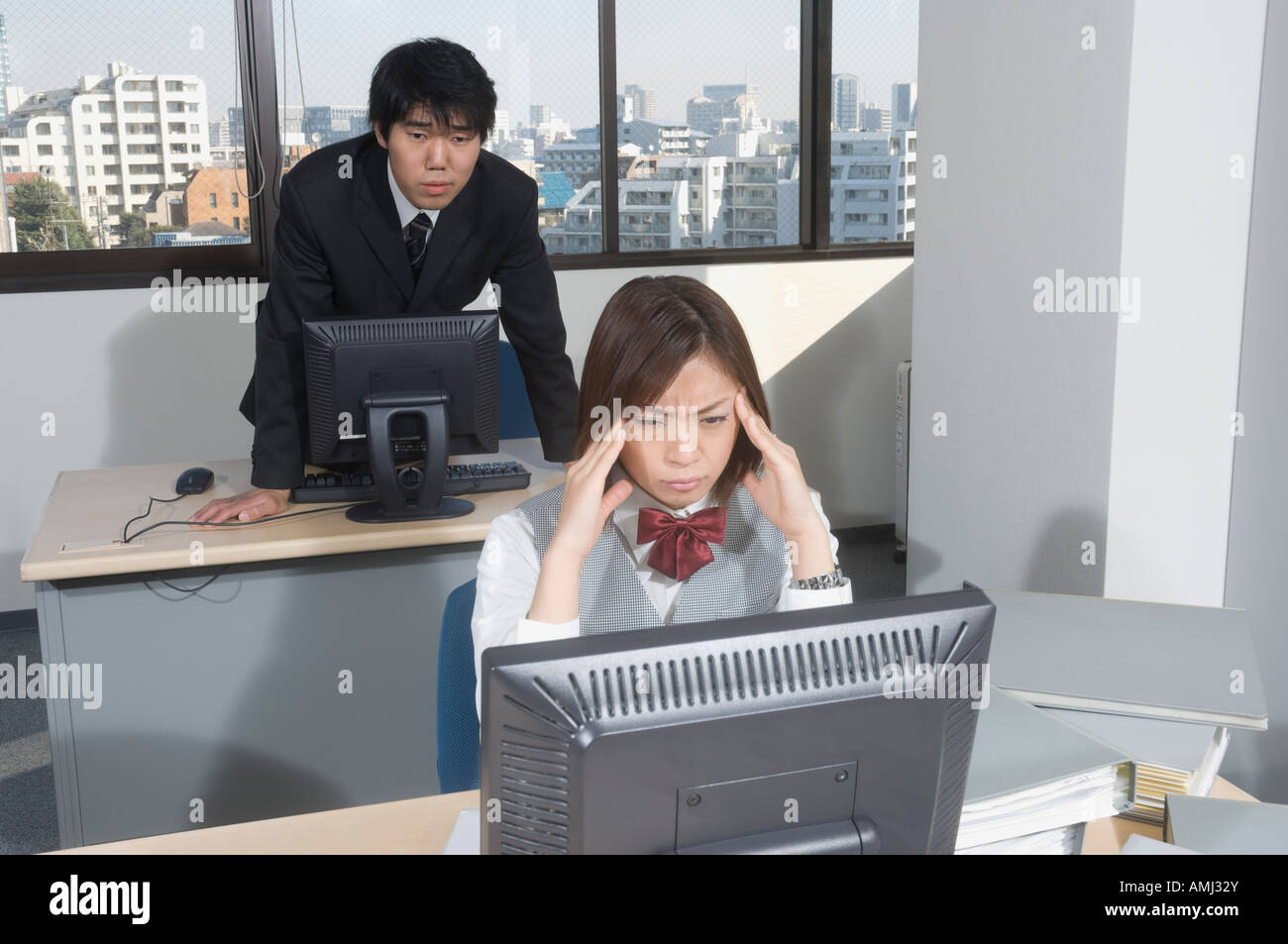 Office worker rubbing her temples Stock Photo - Alamy