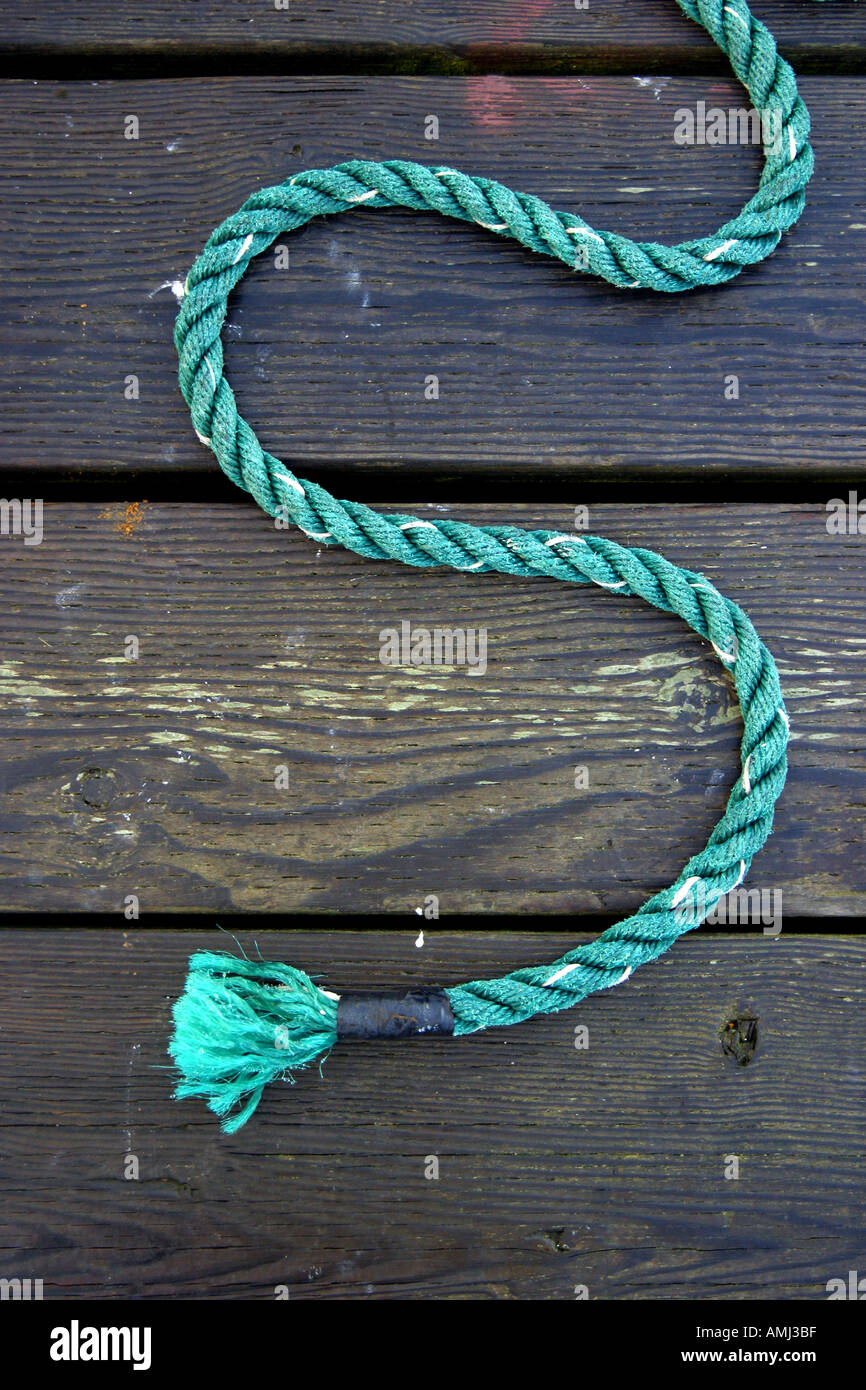 The line or rope from a fishing boat forms an S curve on the dock Stock ...