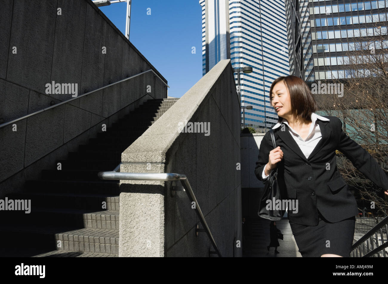Woman running up stairs suit hi-res stock photography and images - Alamy