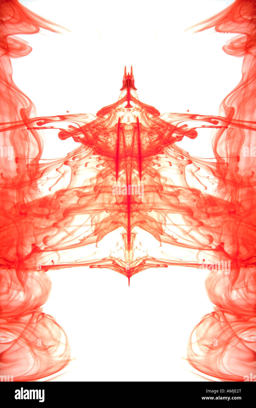 Red ink flowing through water forming an abstract pattern Stock Photo