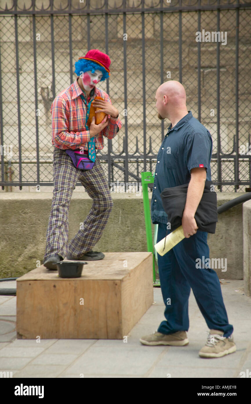 Pedestrian and street mime clown across from the Notre Dame Cathedral Paris France Stock Photo