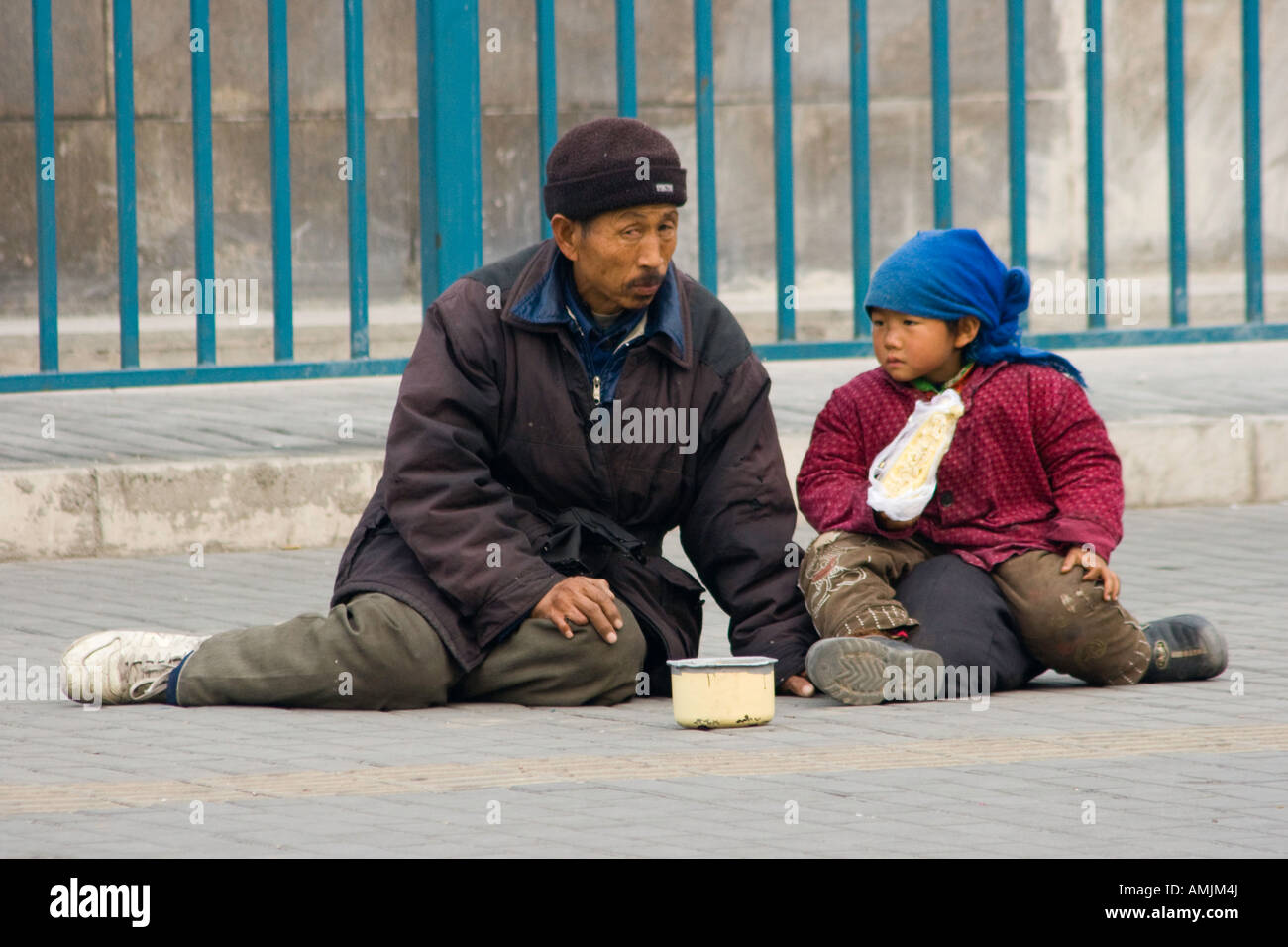 Chinese Man and Young Girl Begging in the Streets of Beijing China Stock Photo