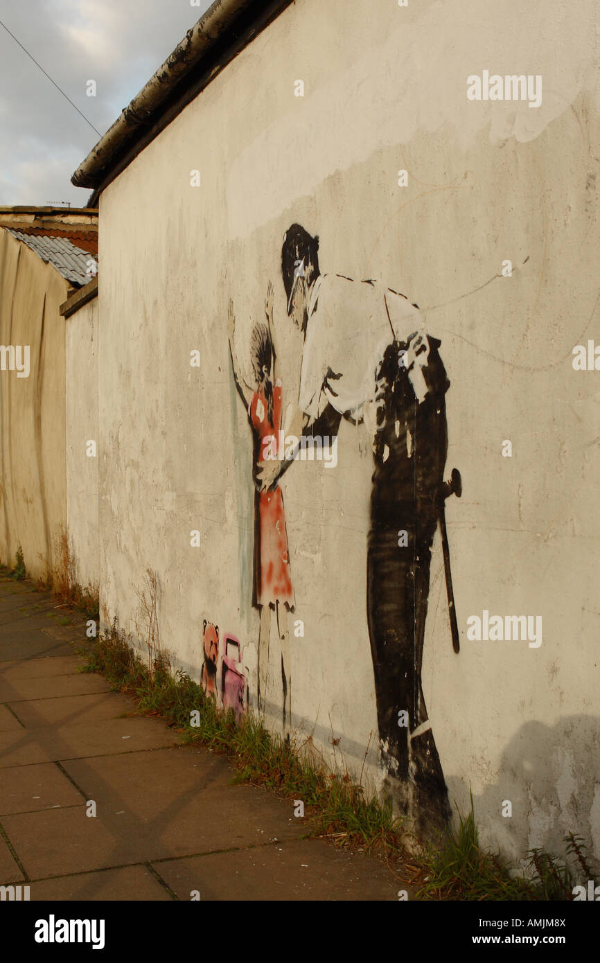 Banksy street art graffiti showing a policeman searching a young girl