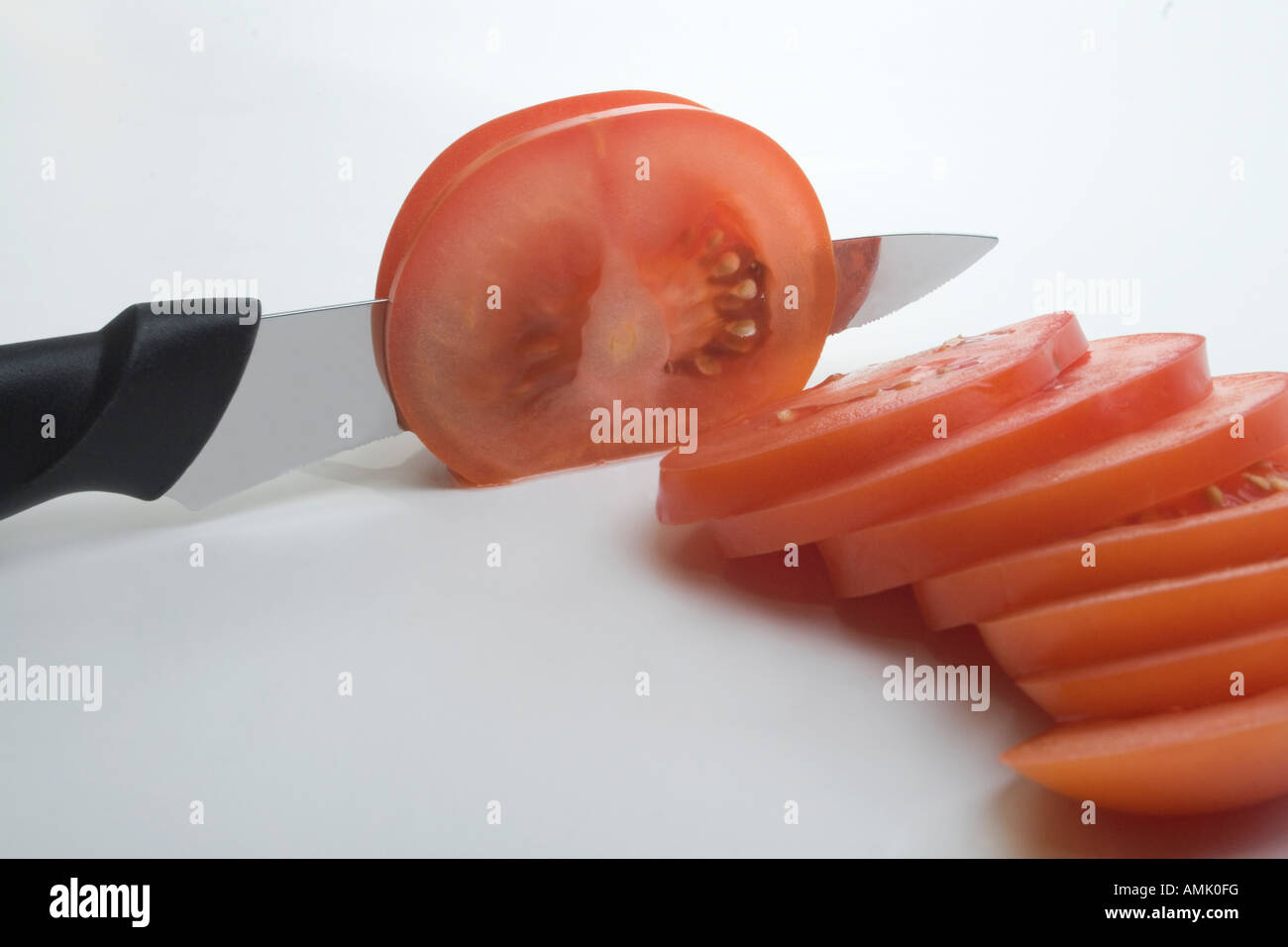Knife slicing tomatoes Stock Photo Alamy