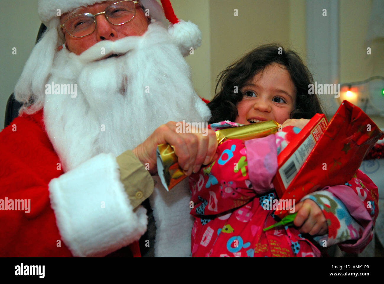 5 year old girl pulling xmas cracker in Santas Grotto, St John's Wood, north London, UK. Stock Photo