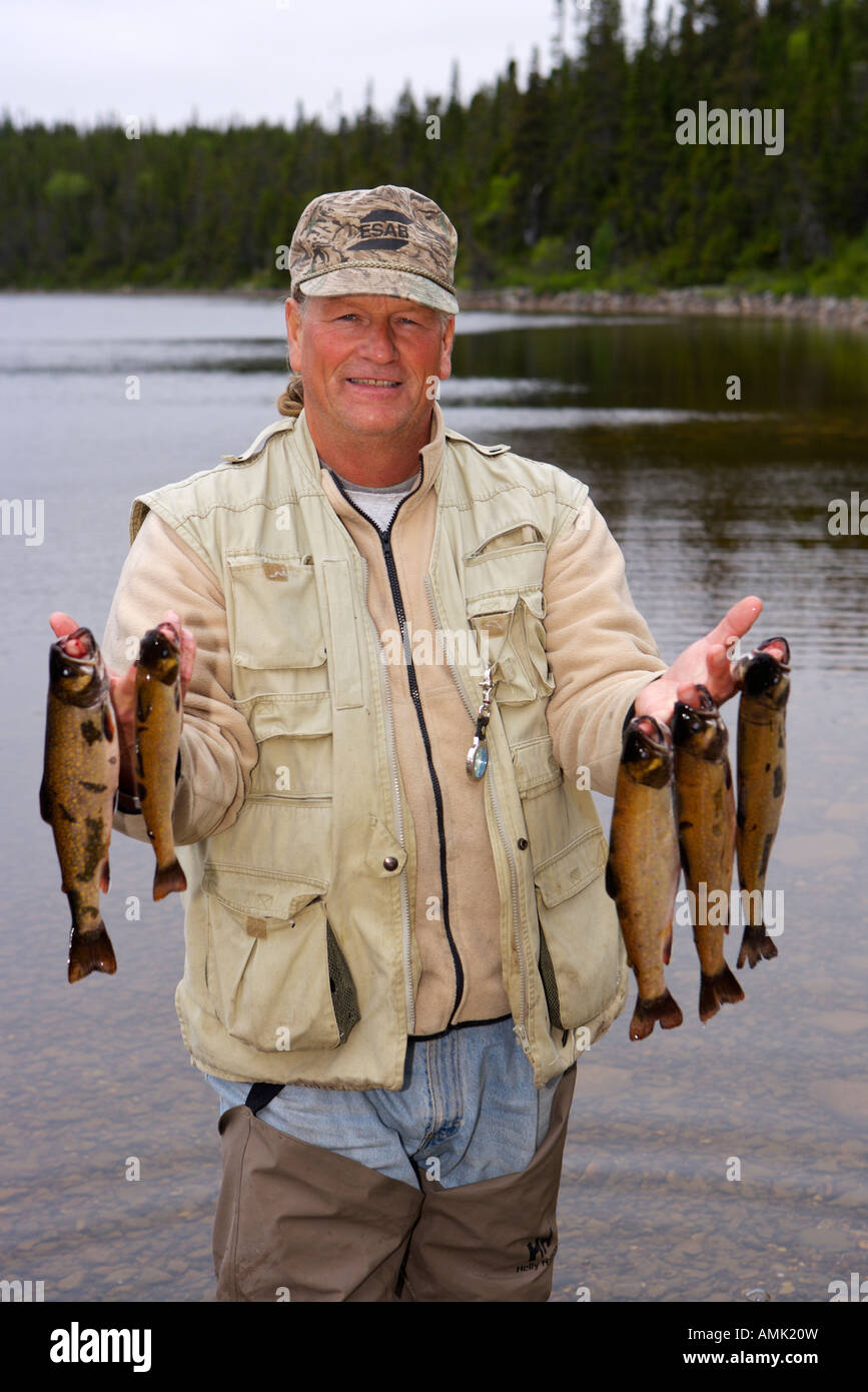 Fisherman with a catch of Speckled Trout, caught near Tuckamore Lodge, Main Brook, Northern Peninsula, Newfoundland, Canada. Stock Photo