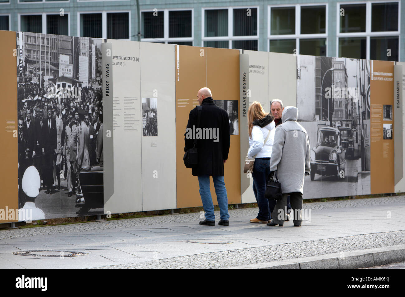 tourists read the history of the berlin wall at checkpoint charlie ...