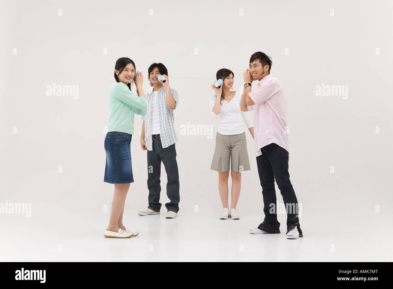 Four people using string telephone Stock Photo - Alamy