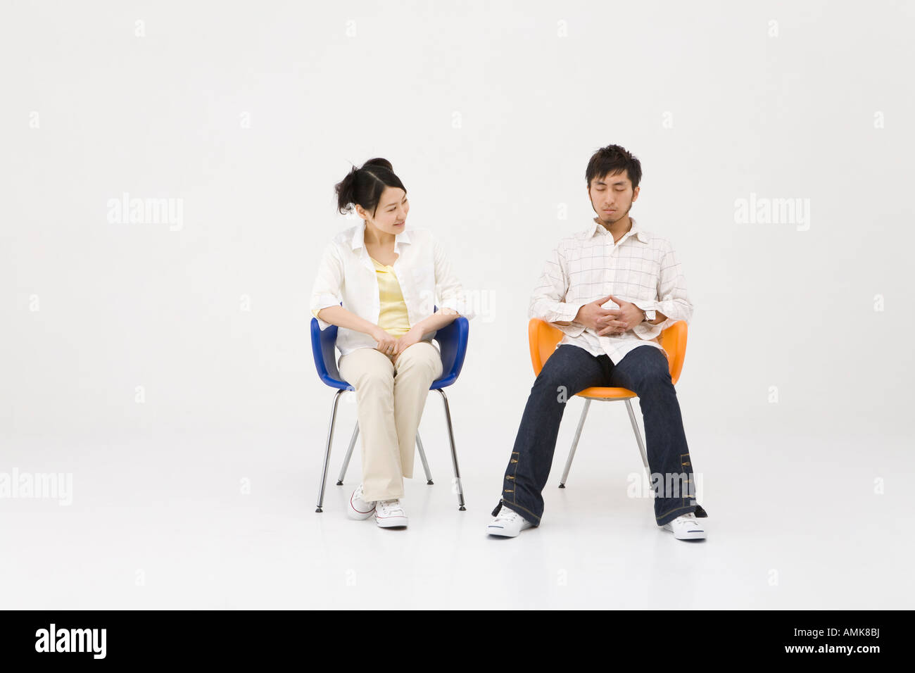 Two young people sitting in chairs Stock Photo Alamy