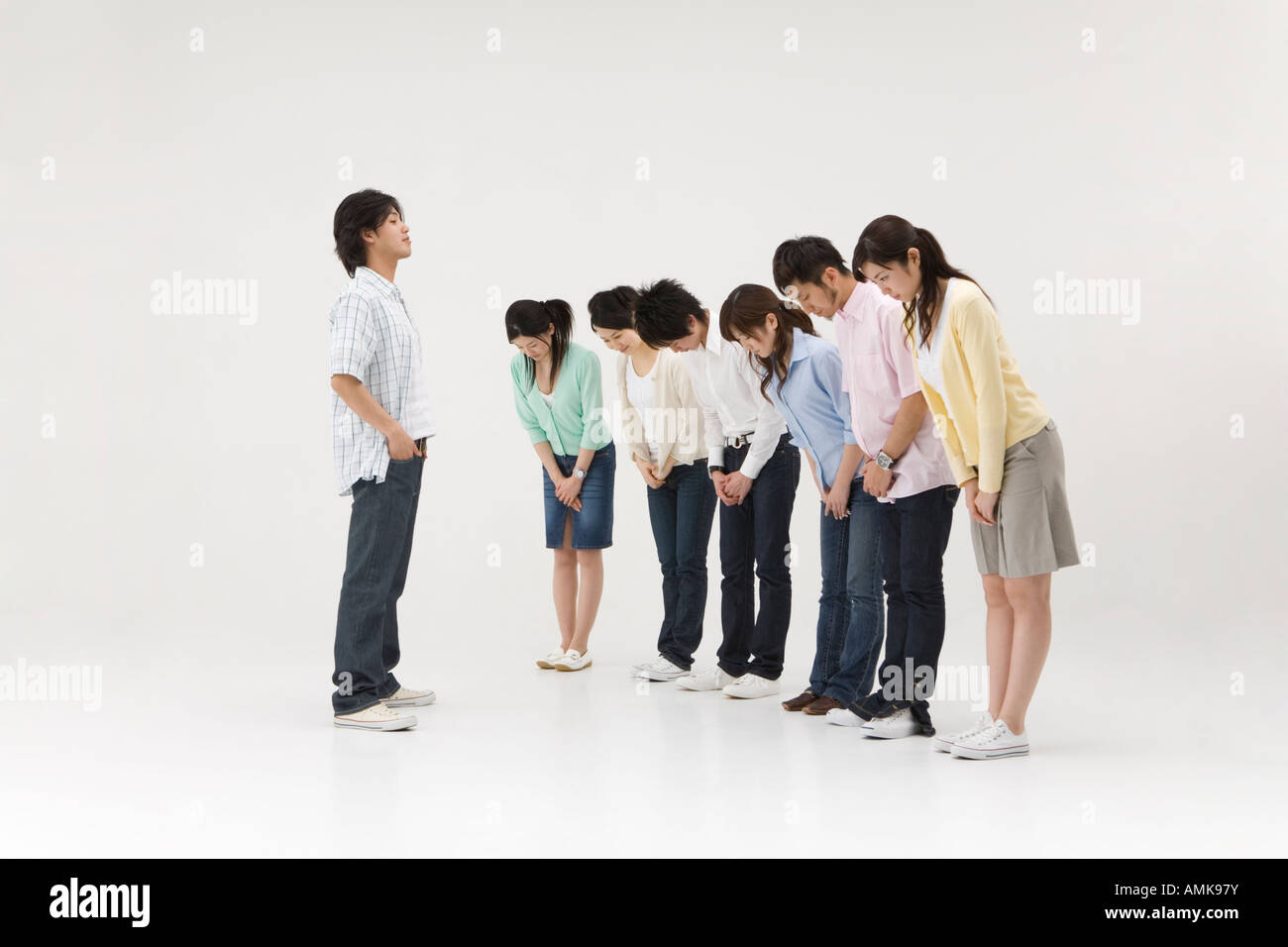 Group of people bowing to a young man Stock Photo