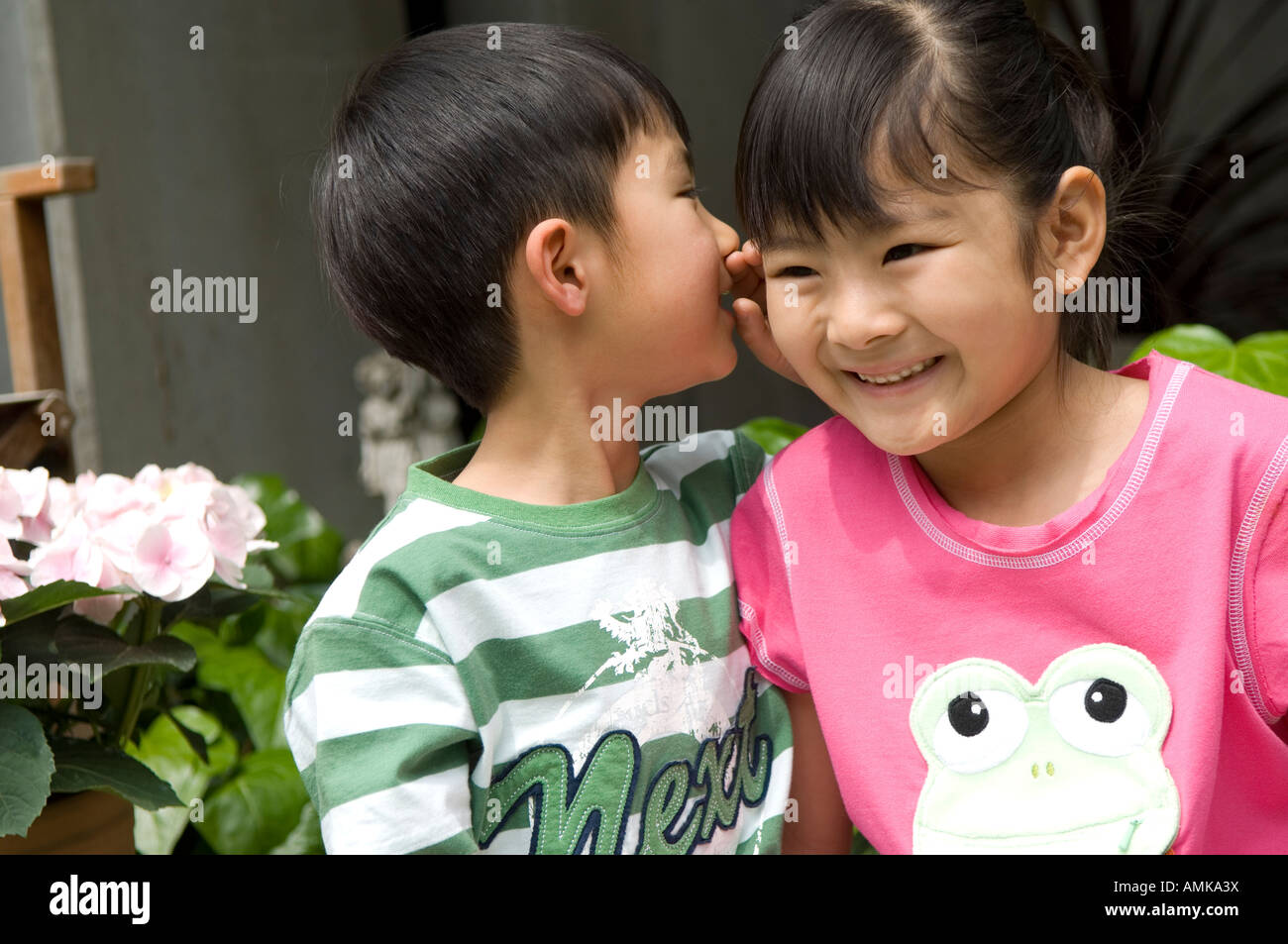 Boy whispering to girl Stock Photo - Alamy