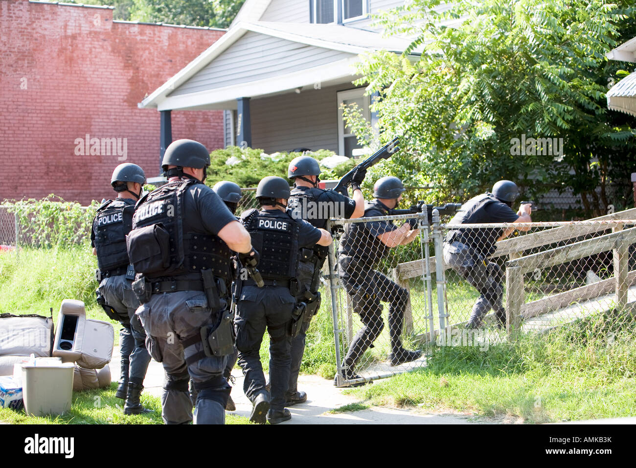 Police officers from tactical narcotics unit carrying out high risk search warrant in suspected drug house. Kansas City SWAT. Stock Photo