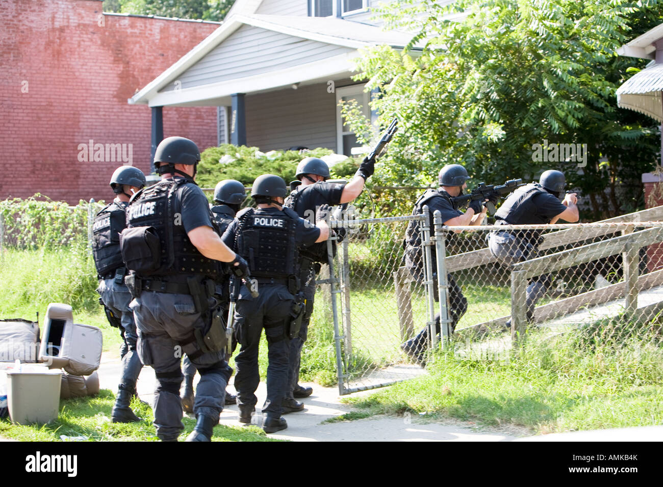 Police officers from tactical narcotics unit carrying out high risk search warrant in suspected drug house. Kansas City SWAT. Stock Photo