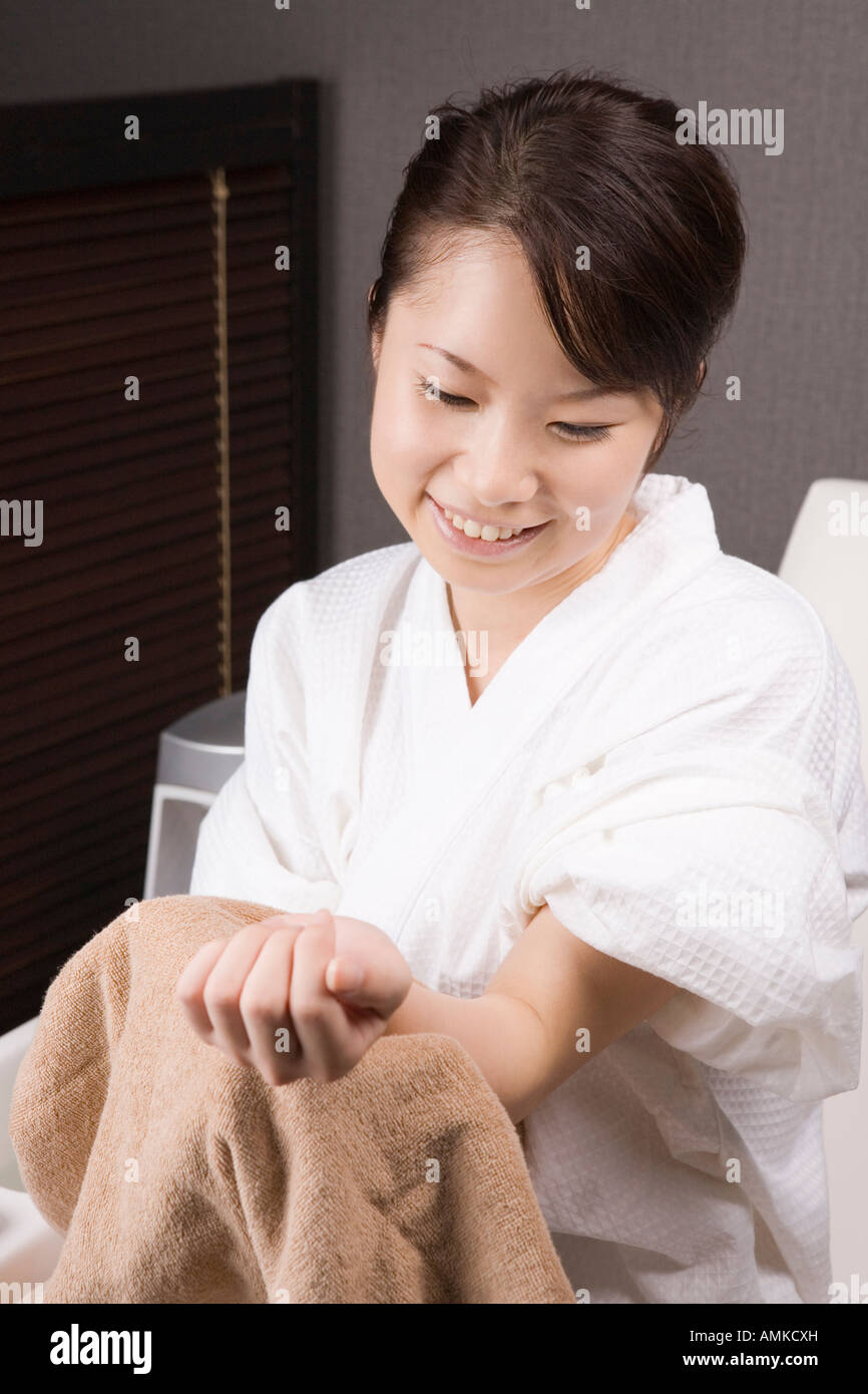 Young woman wiping hand with towel Stock Photo