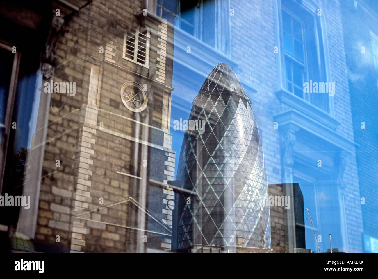 Contrasting styles of London architecture: reflections of the Swiss Re 'Gherkin' building and St Botolph's church, Aldgate. Stock Photo
