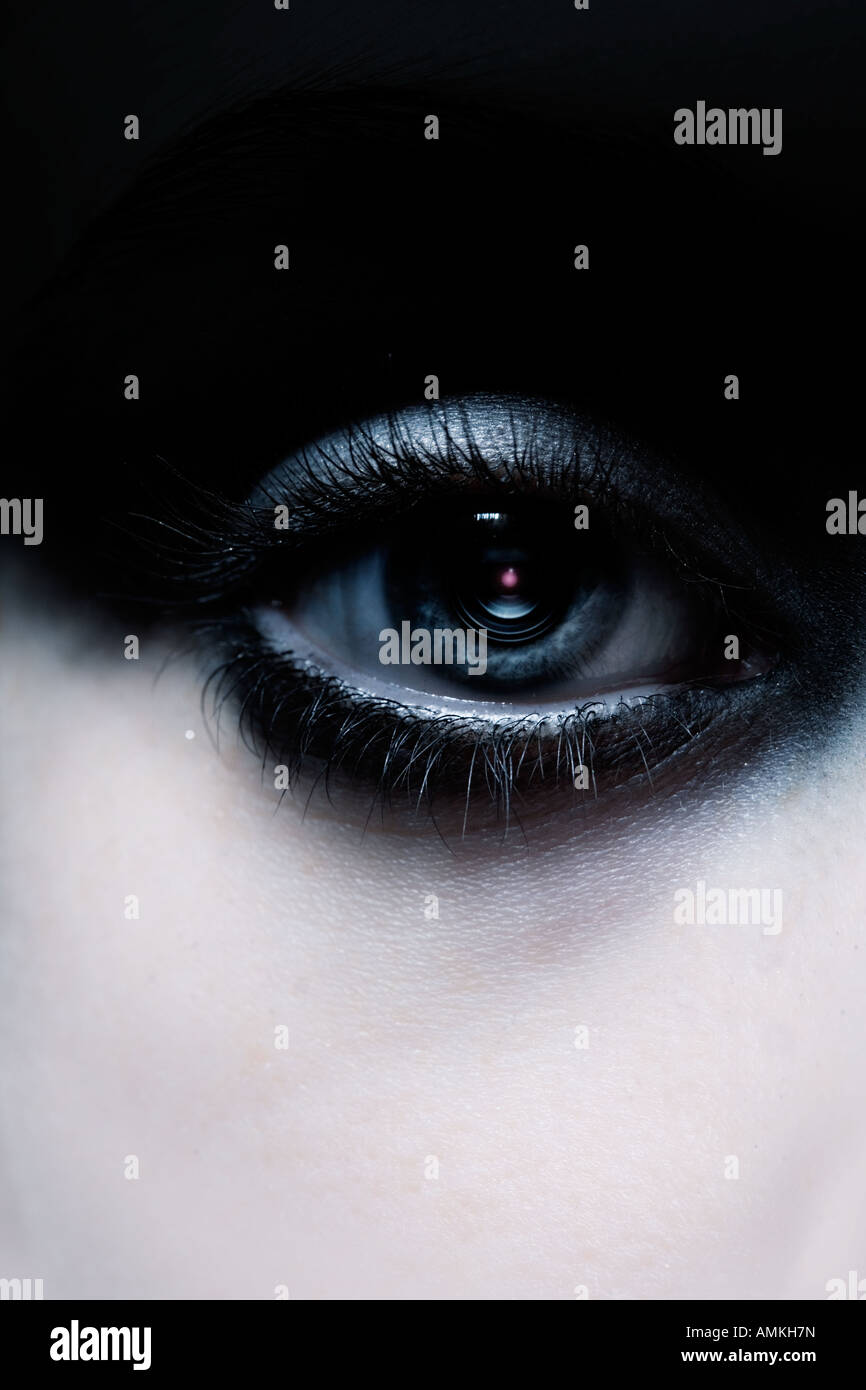 close up of a human eye with a camera lens instead of a pupil Stock