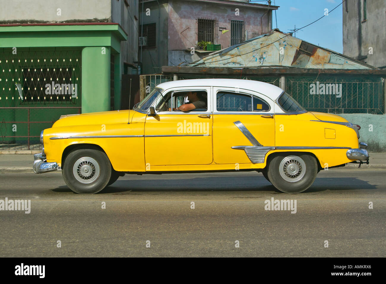 Yellow Pontiac driving through the streets of Havana Cuba Stock Photo