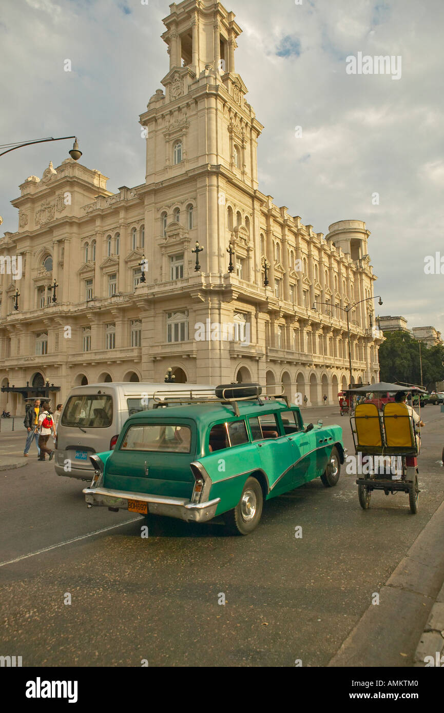 Turquoise 1955 Buick car and bicycle taxi driving the streets of Old Havana Cuba Stock Photo