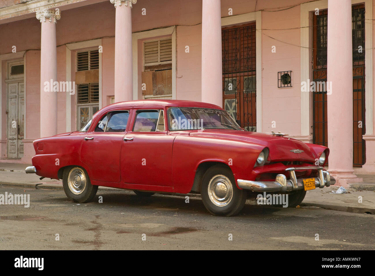 Vintage car in front of pink building in Havana Cuba Stock Photo