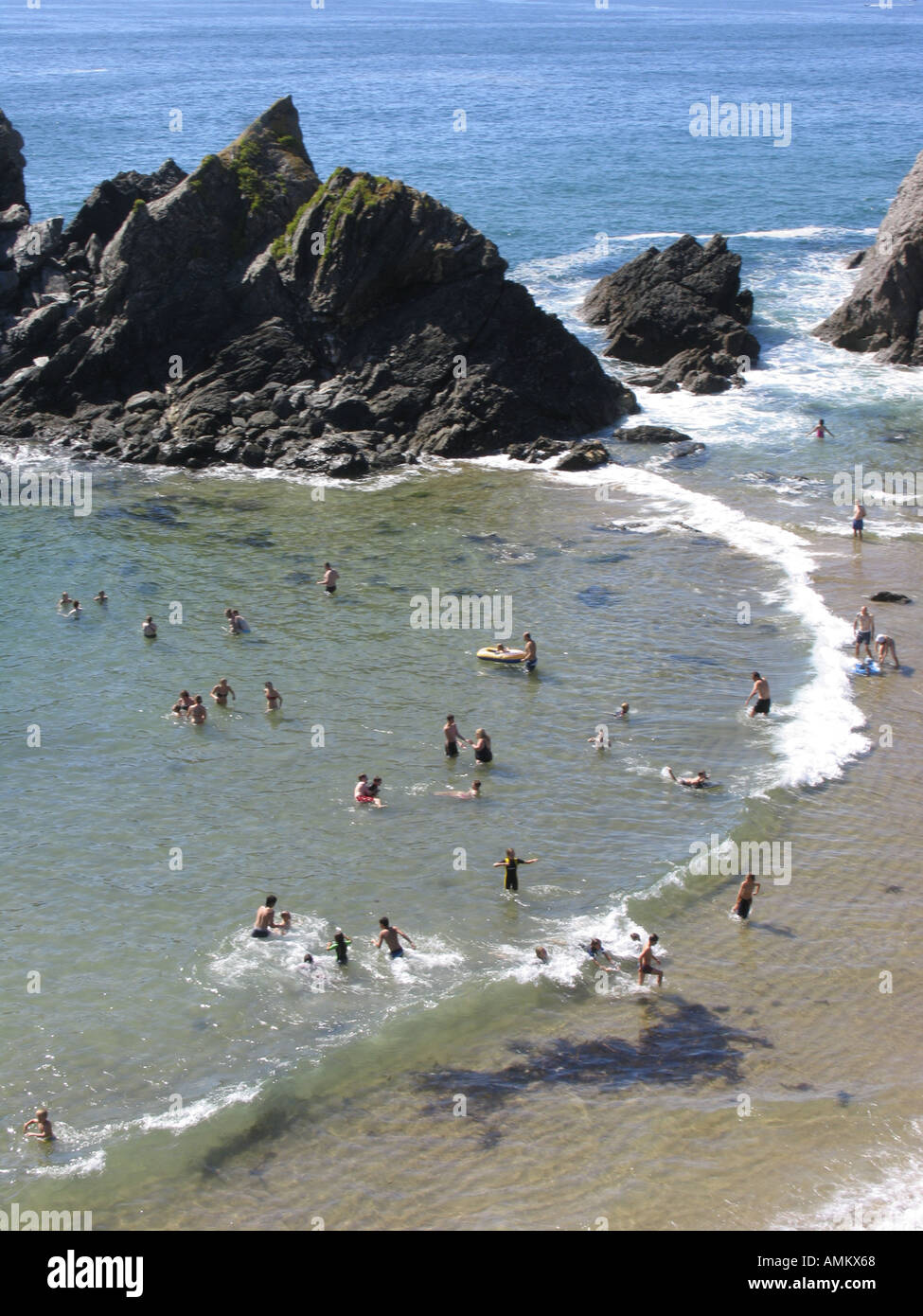 Wide view of holidaymakers and daytrippers enjoying the summer sun on the beach at Soar Mill Cove, South Devon, UK Stock Photo
