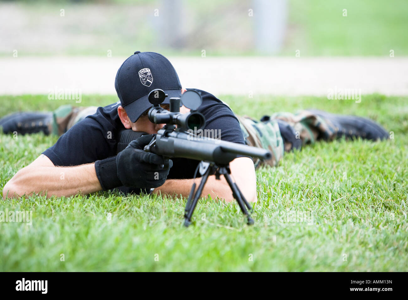 SORT, prison SWAT team, sniper in position observing a target. SORT typically handle very serious situations such as riots. Stock Photo