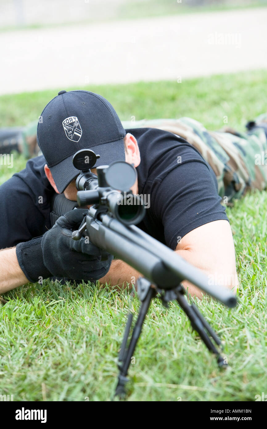 SORT, prison SWAT team, sniper in position observing a target. SORT typically handle very serious situations such as riots. Stock Photo