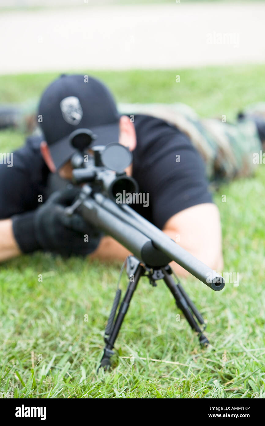 SORT, prison SWAT team, sniper in position observing a target. SORT typically handle very serious situations such as riots. Stock Photo
