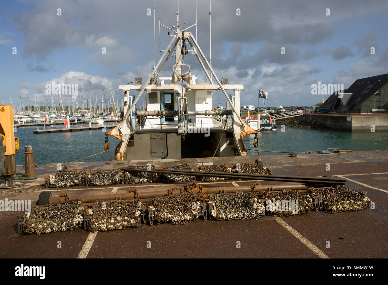Scallop dredging nets with fishing trawlers Quineville harbour Normandy France Stock Photo