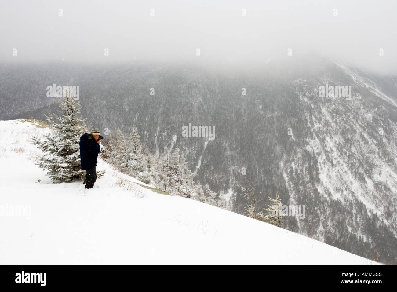 A photographer in the fresh snow on Mount Willard in New Hampshire USA ...