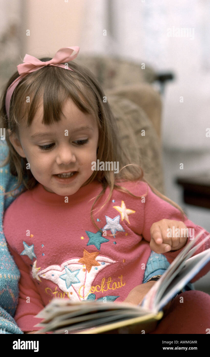 Four year old girl reading a book Stock Photo