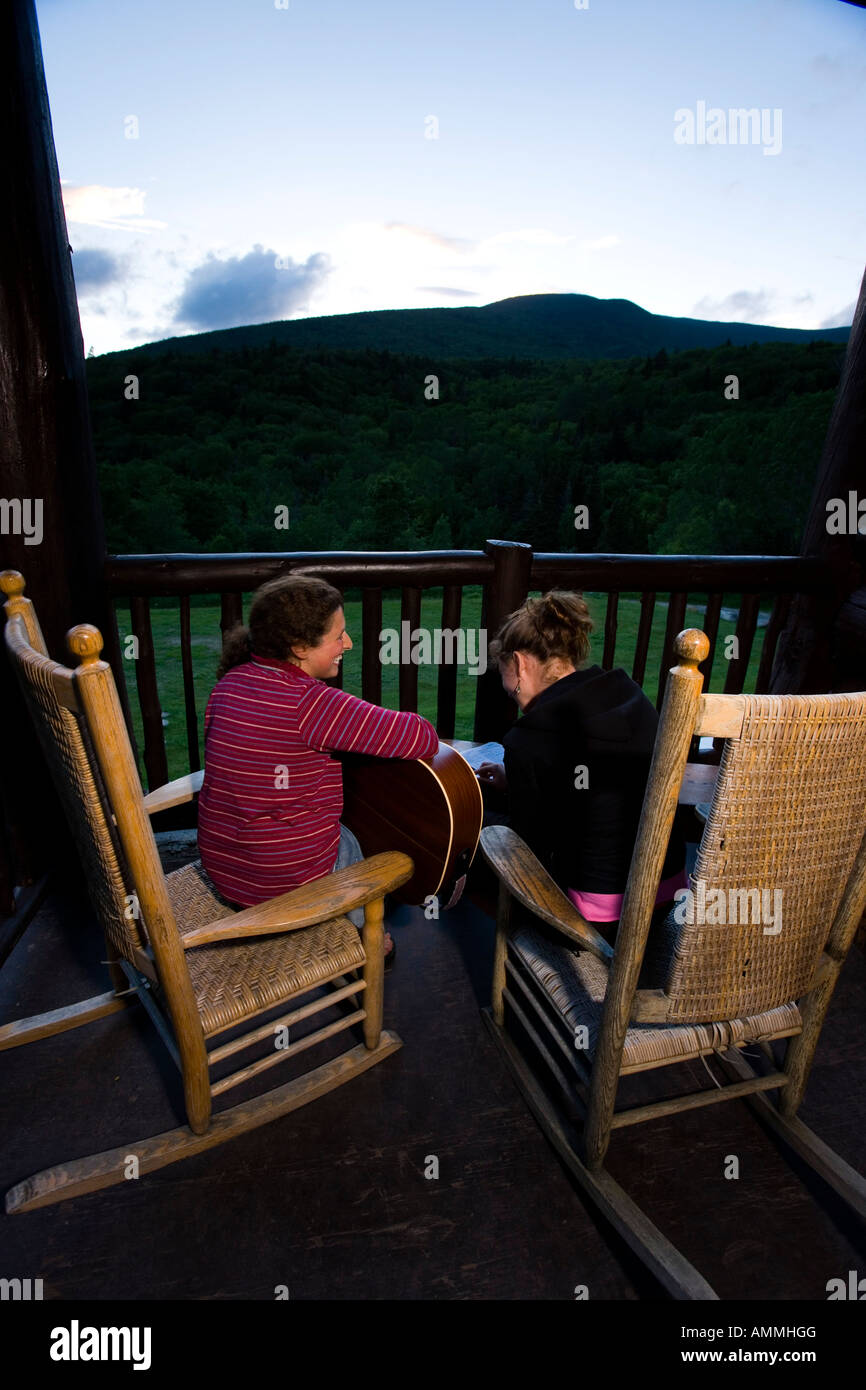 Two young women sing on the porch at the Dartmouth Outing Club s Moosilauke Ravine Lodge Stock Photo