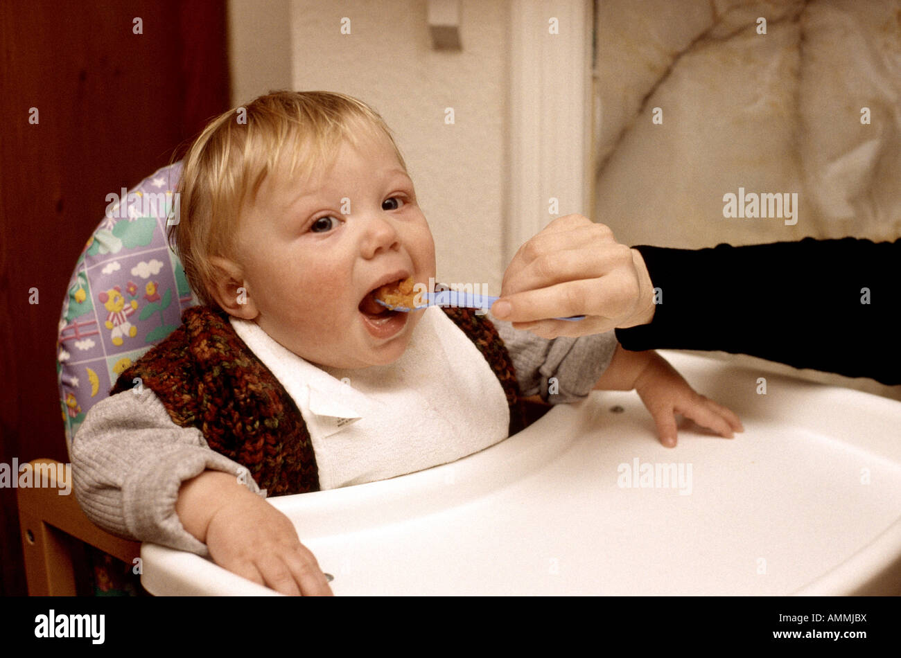 eight month old boy spoon fed Stock Photo