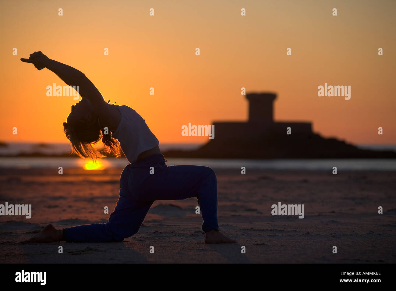 Lady practising Yoga on St Ouens beach Jersey channel islands Stock