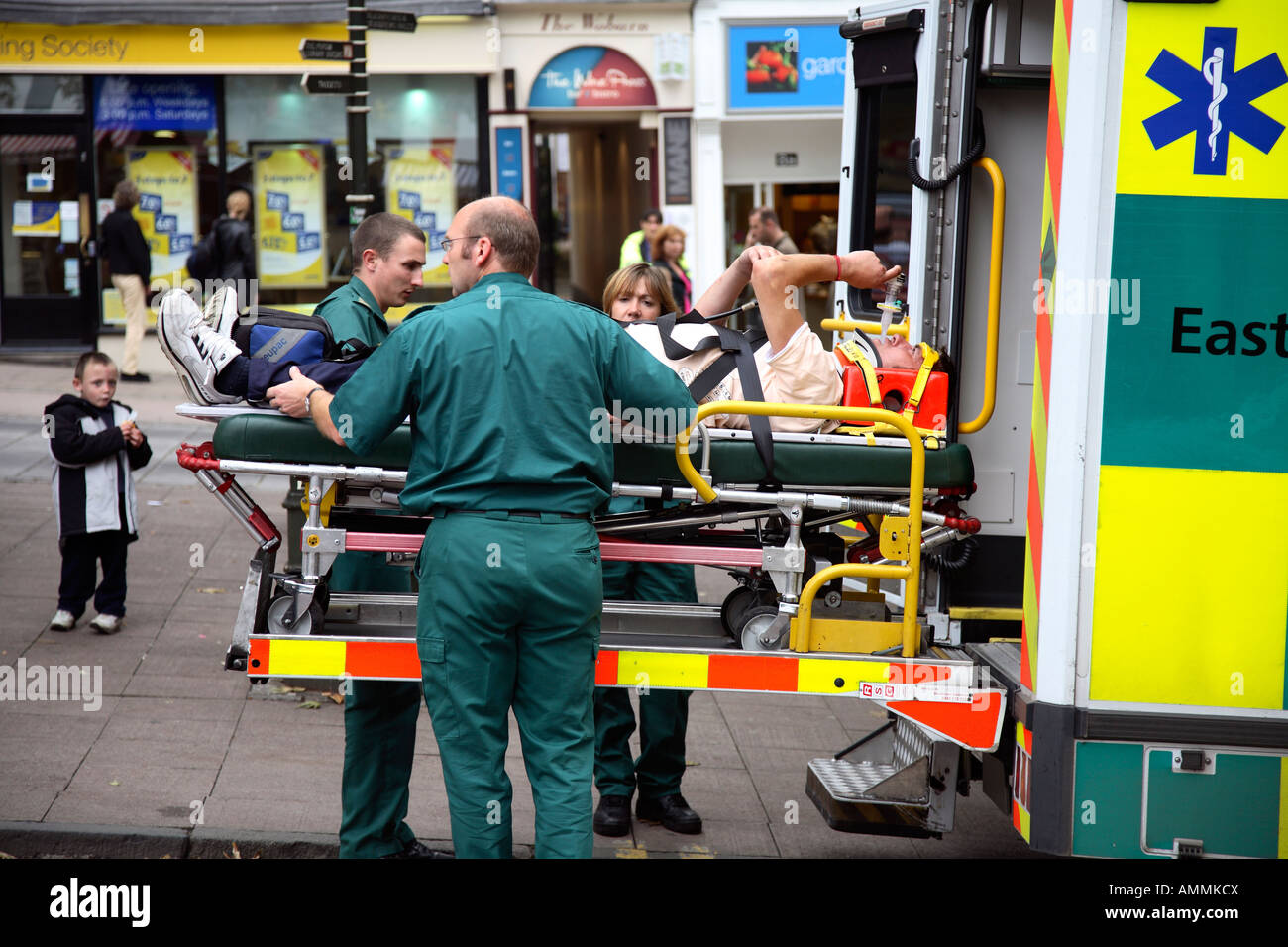 Paramedics placing an injured man on a stretcher and taking him to hospital. Stock Photo