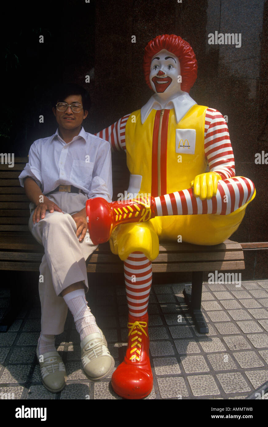 Man sits beside Ronald McDonald at McDonald s restaurant in Beijing in Hebei Province People s Republic of China Stock Photo