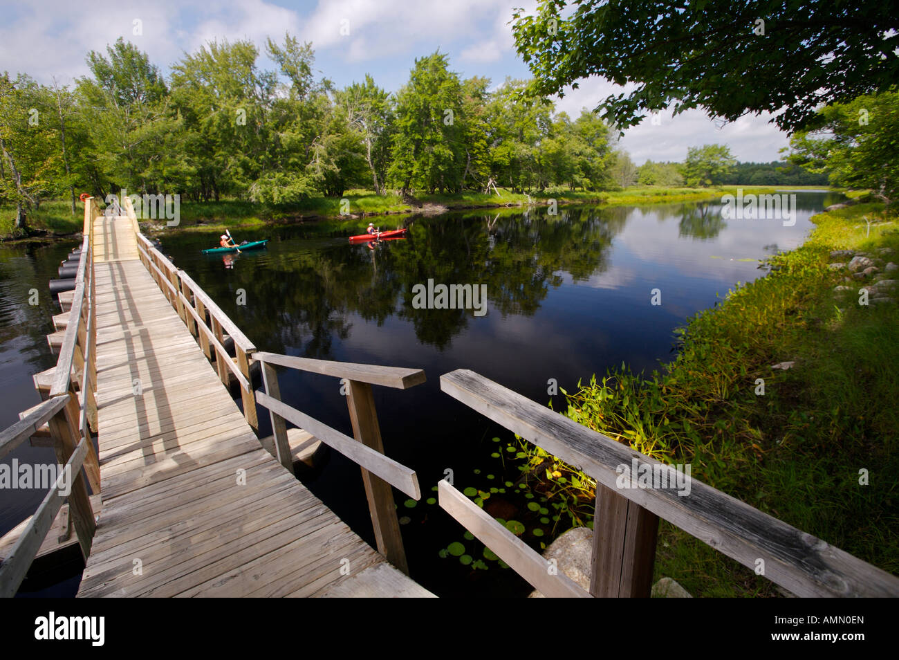 Foot bridge and kayakers on the Mersey River in Kejimkujik National Park and National Historic Site of Canada, Nova Scotia Stock Photo