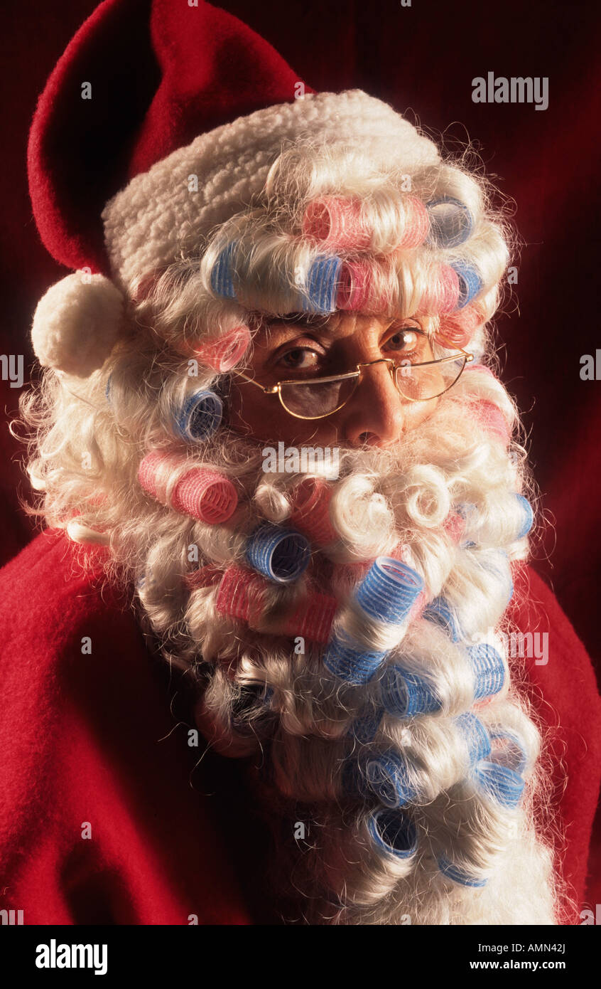 A lady Mother Christmas in traditional Father Christmas outfit with curlers in her beard Stock Photo Alamy