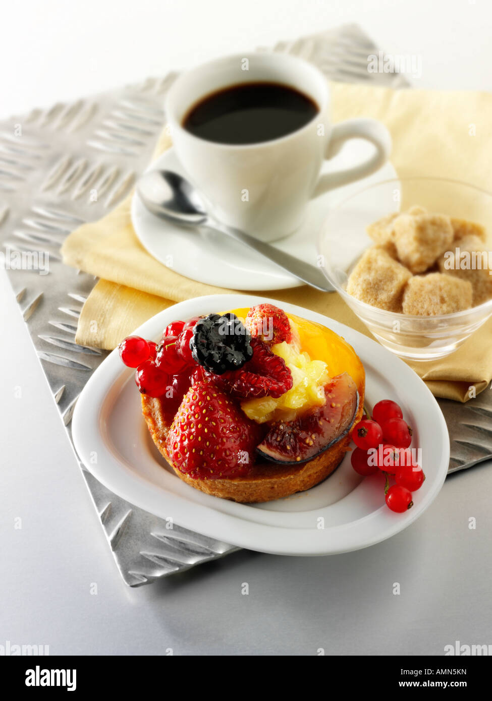 espresso coffee, with red currants and wild strawberry custard tart pastry in a cafe setting with coffee cup Stock Photo