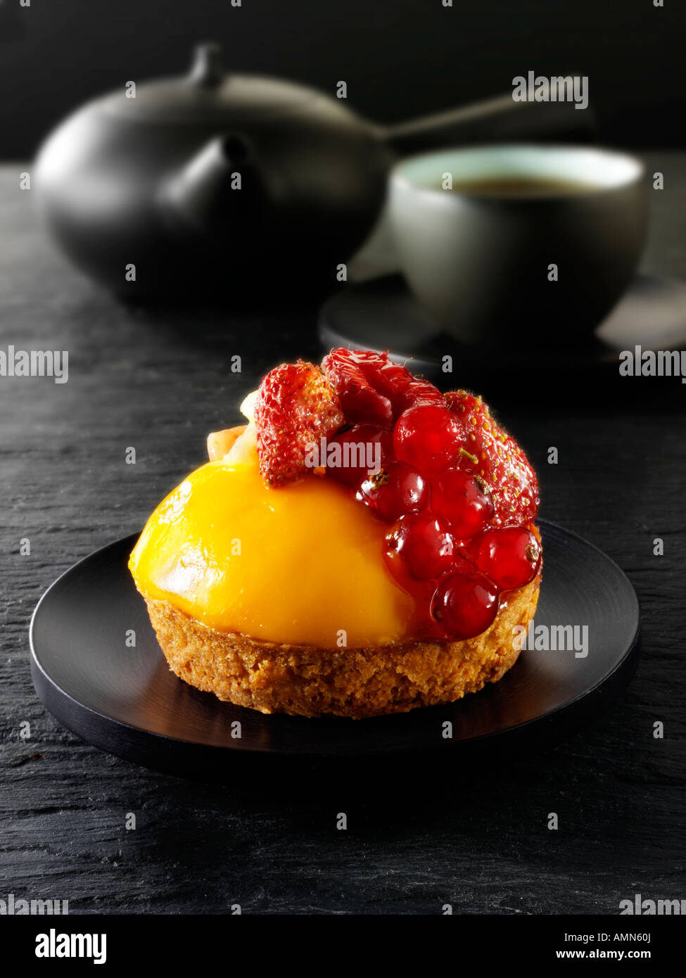 espresso coffee, with red currants and wild strawberry custard tart pastry in a cafe setting with tea cup Stock Photo
