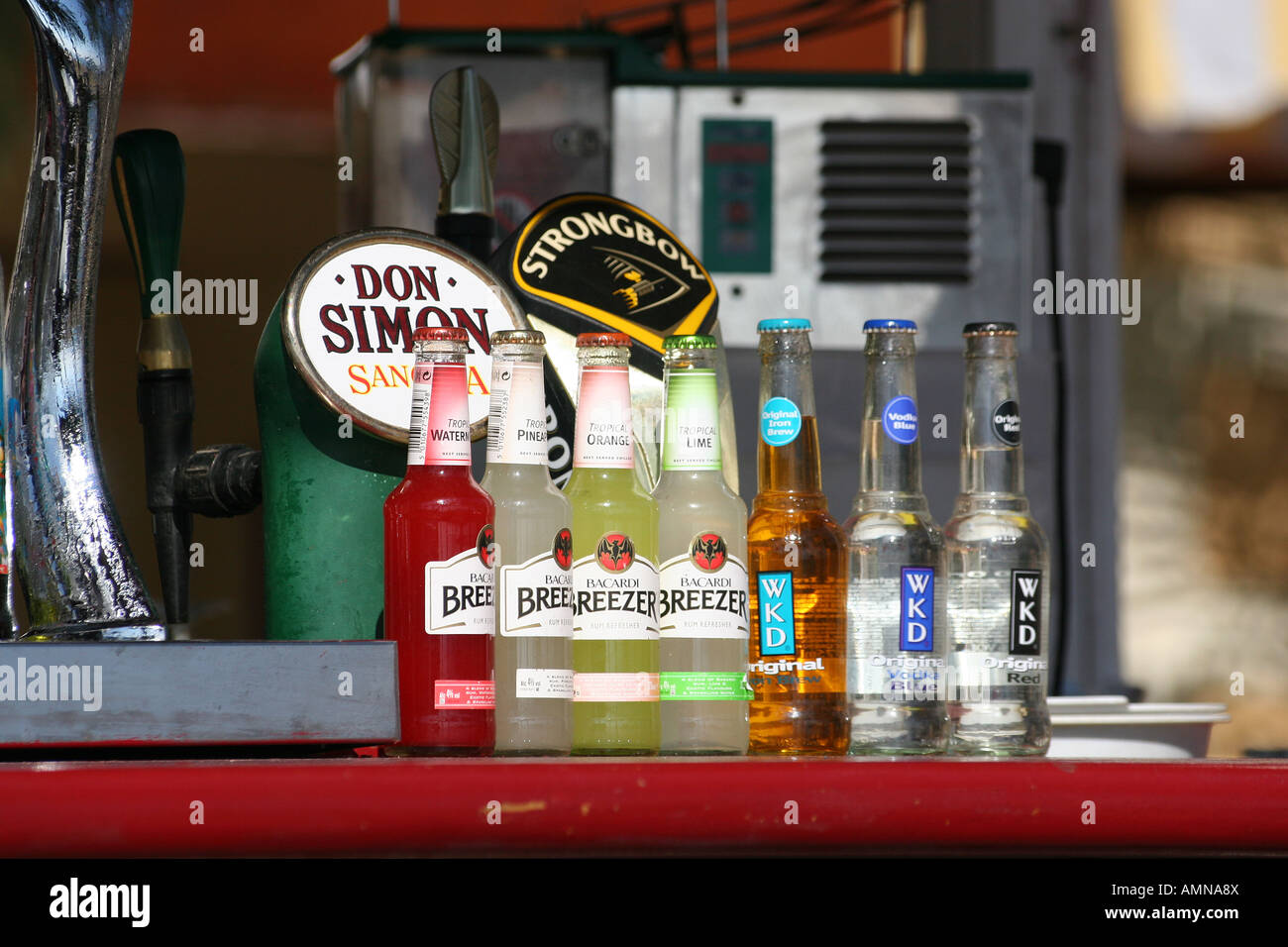 Various alcoholic bottled drinks and beer pumps on a sea front bar in