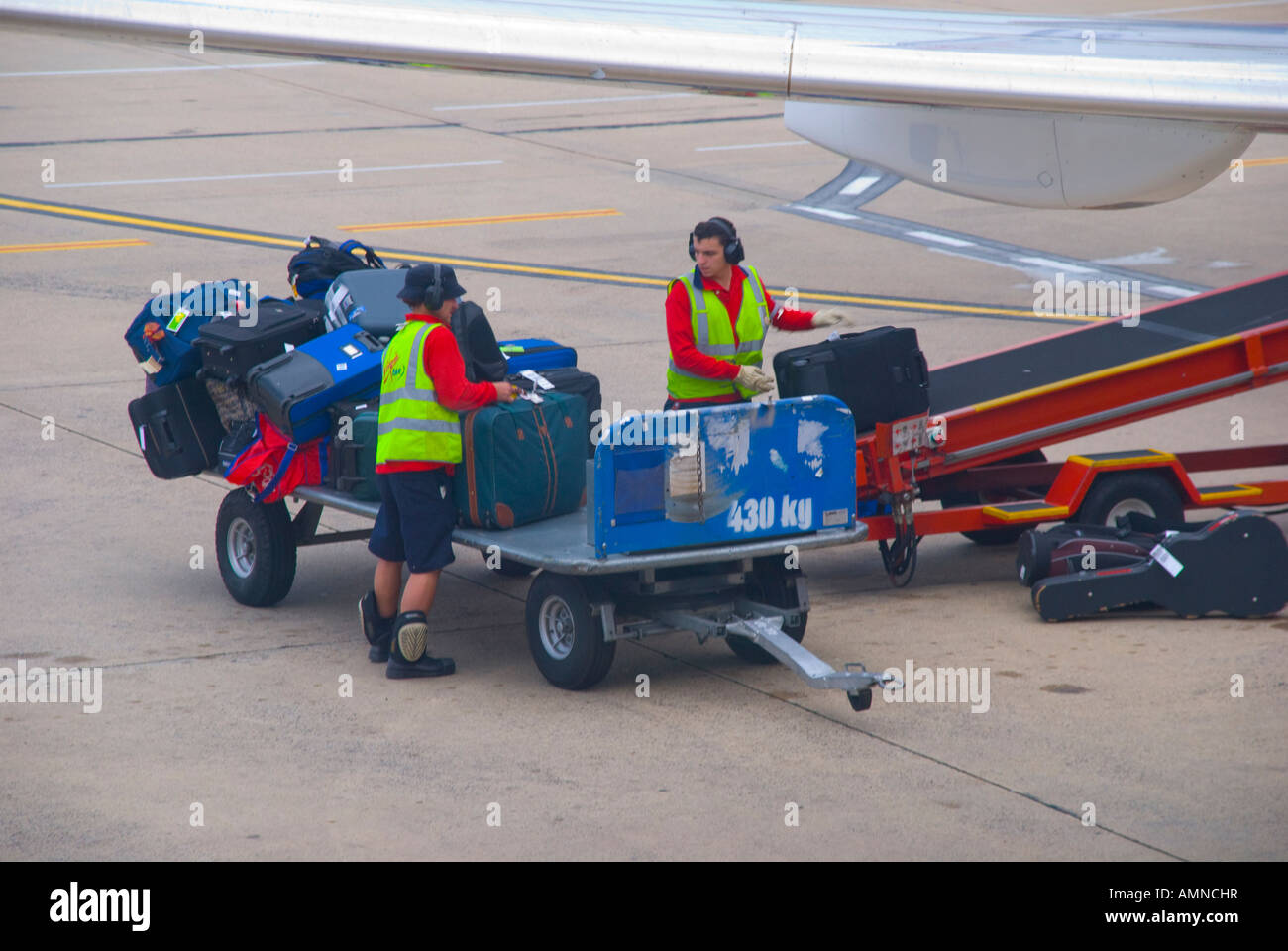 Baggage handlers loading luggage onto a passenger aircraft in Sydney Australia Stock Photo